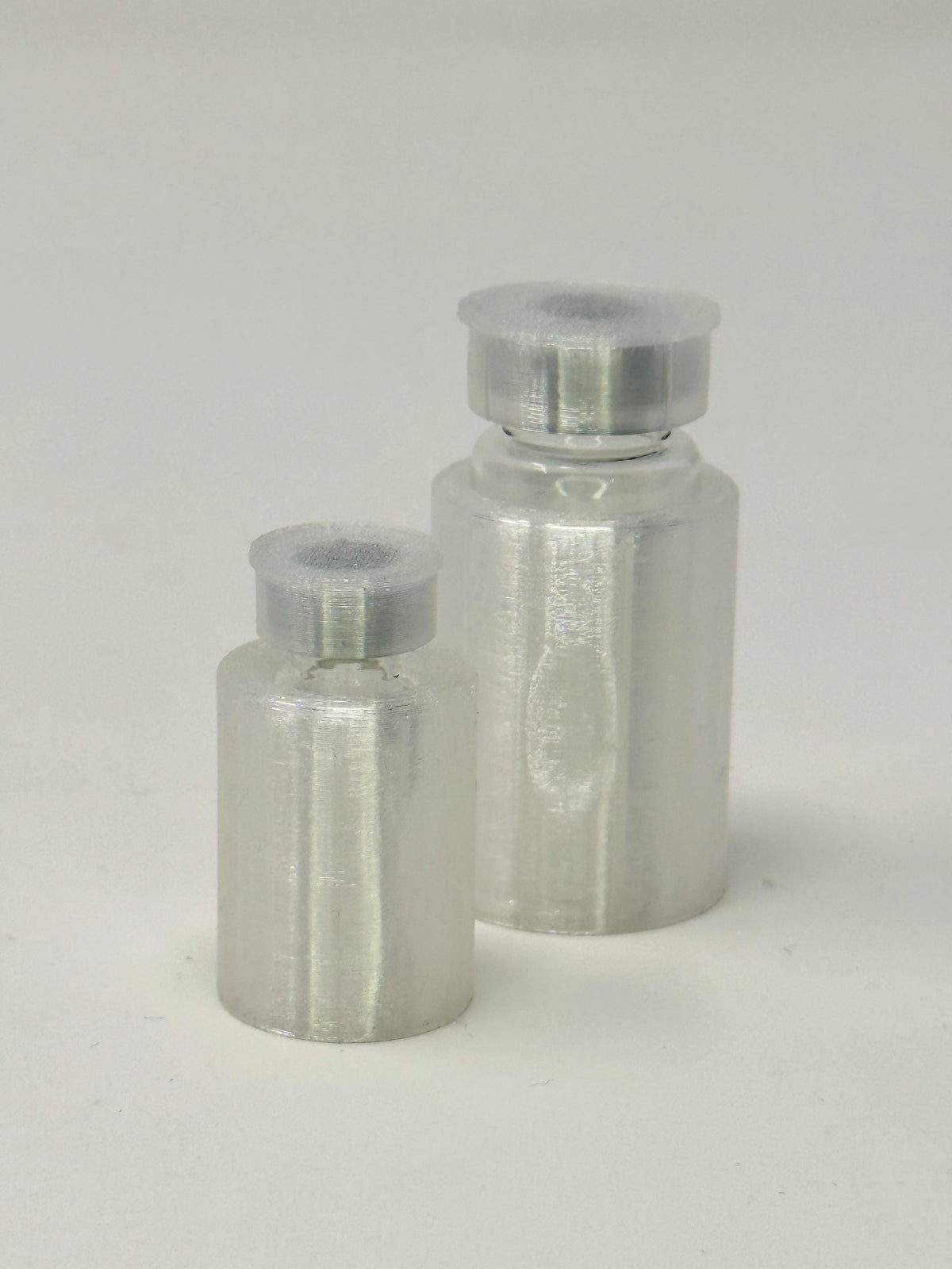VialLock Clear vial sleeves shown on 3 mL and 10 mL demonstration vials. Each order contains three sleeves of one selected size; matching caps included only with the cap option.
