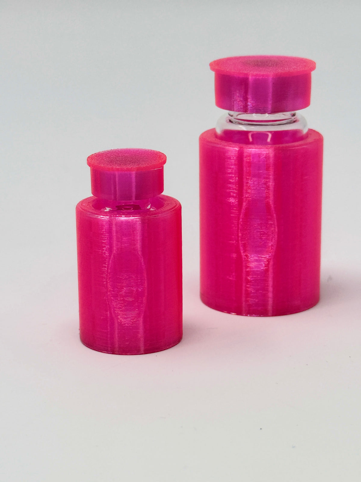 VialLock Translucent Pink vial sleeves shown on 3 mL and 10 mL demonstration vials. Each order contains three sleeves of one selected size; matching caps included only with the cap option.