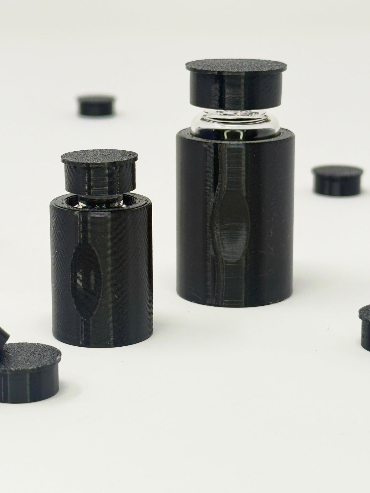 VialLock Black vial sleeves shown on 3 mL and 10 mL demonstration vials. Each order contains three sleeves of one selected size; matching caps included only with the cap option.
